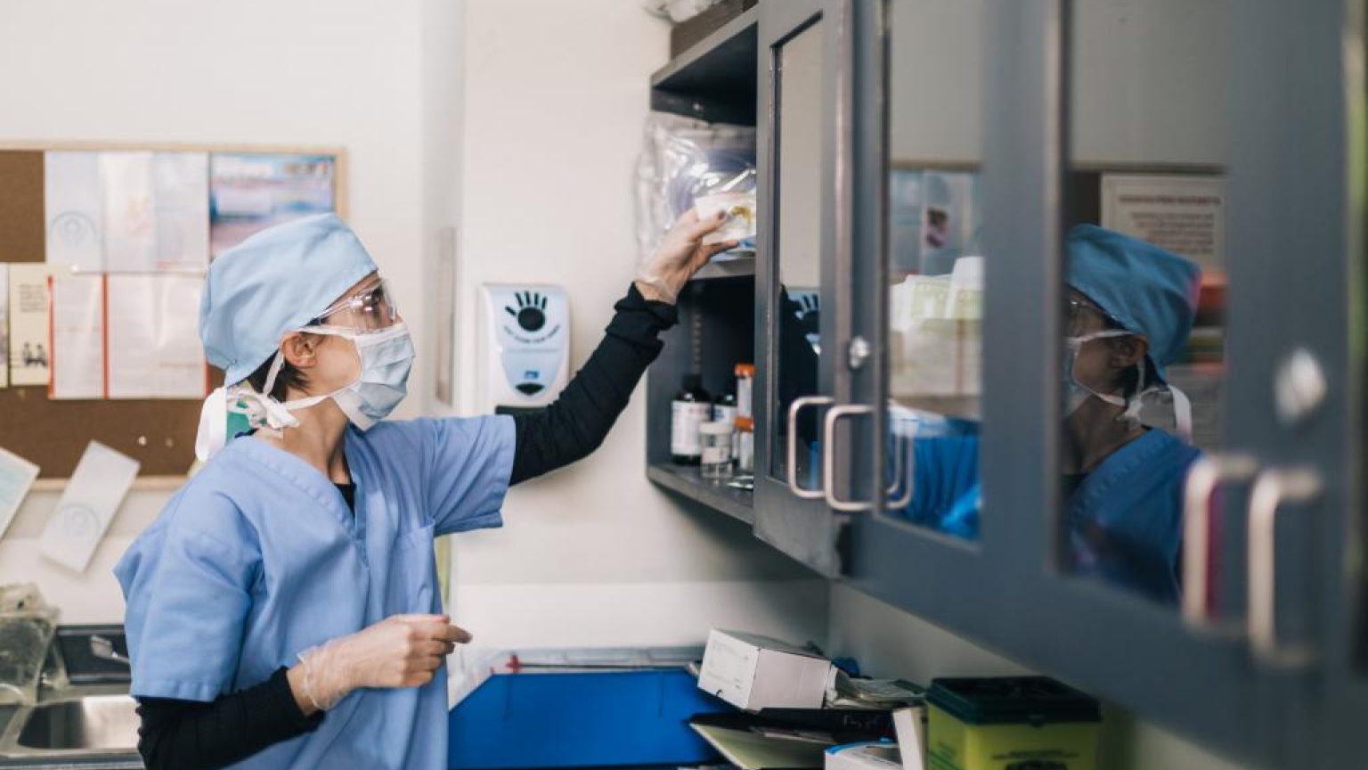 Doctor reaches towards shelf 1024x683