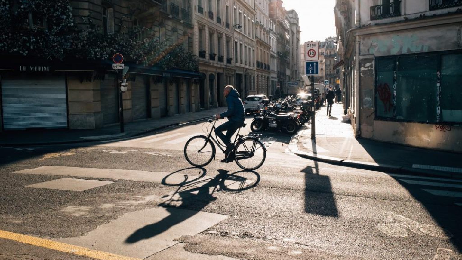 Someone riding their bike on a quiet city street 1024x683